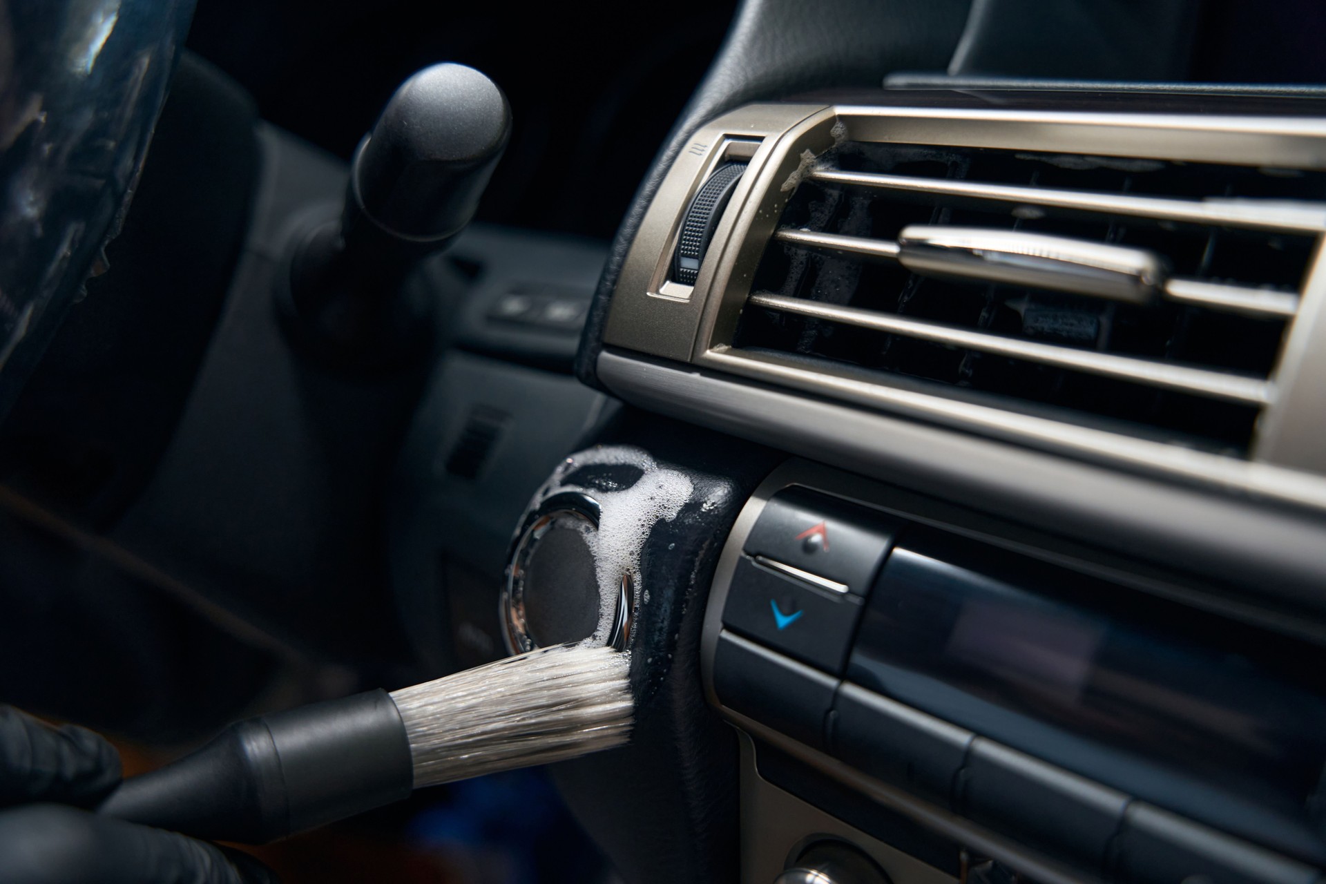 Specialist in protective gloves carries out detailing in car interior